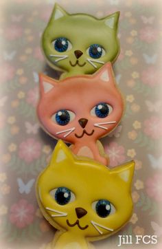 three cats are sitting next to each other on a flowered surface with butterflies in the background