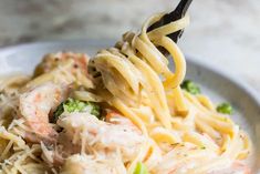 a close up of a plate of pasta with shrimp and broccoli