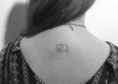 an elephant tattoo on the back of a woman's neck