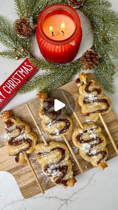 christmas pastries on a cutting board next to a candle