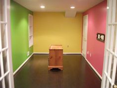 an empty room with wooden floors and colorful walls