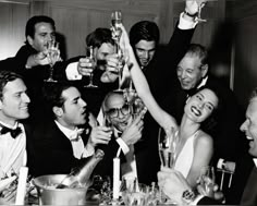 a group of men and women toasting at a dinner table