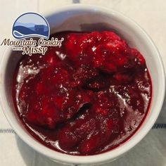 a white bowl filled with cranberry sauce on top of a table