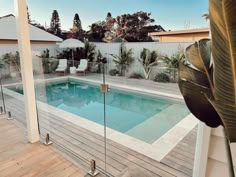 an empty swimming pool surrounded by wooden decking