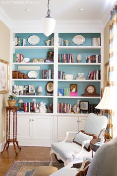 a living room filled with lots of furniture and bookshelves covered in blue paint