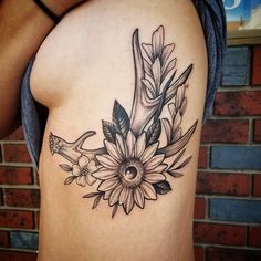 a black and white photo of a woman's stomach with flowers on it