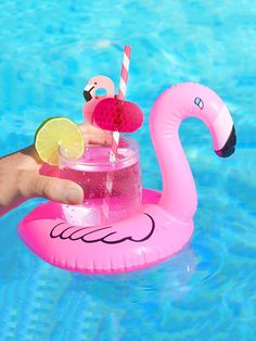 a pink flamingo float floating on top of a pool with a drink in it