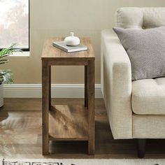 a living room with a couch, table and potted plant on the floor next to it