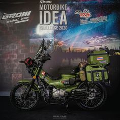 a green motorcycle parked in front of a wall with an advertisement on it's side