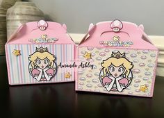 two pink boxes with princesses on them are sitting on a table next to each other