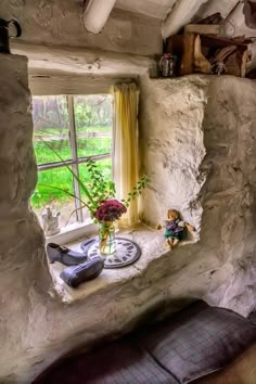 there is a small window in the stone wall with flowers on it and a plate next to it