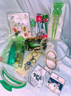 an assortment of items are displayed on a white cloth covered tablecloth, including bracelets and jewelry