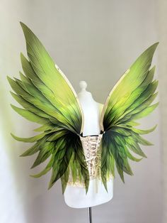 a white mannequin with green wings on it