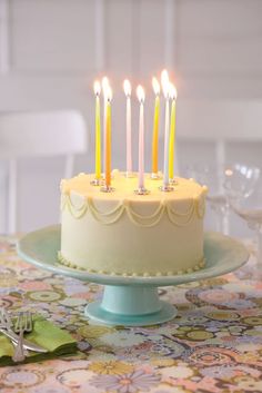 a birthday cake with lit candles sitting on a table