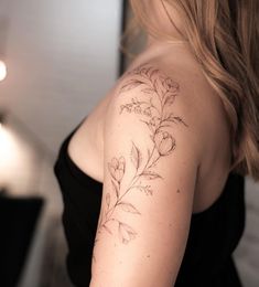 a woman with a flower tattoo on her left arm and right arm behind her back