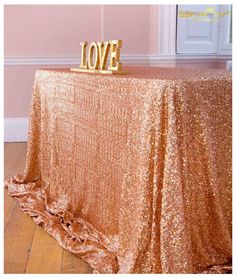 a gold sequin table cloth with the word love on it