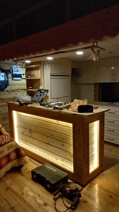 a kitchen with wooden flooring and lights on the counter top in front of it