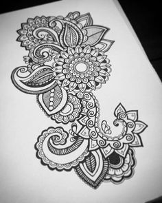 a black and white drawing of an intricate flower design on a piece of paper with ink