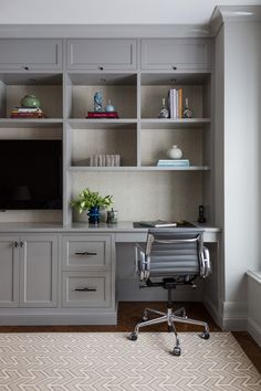 a desk with a chair, bookshelf and television