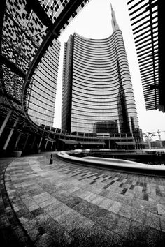 an empty square in front of two tall buildings with circular walkways on each side