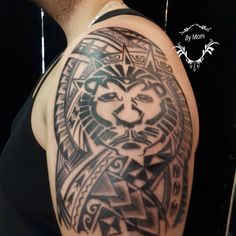 a man with a lion tattoo on his arm and shoulder is looking at the camera