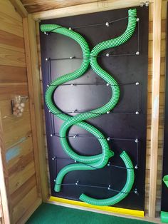 the inside of a shed with green hoses hanging from it's side wall