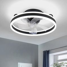 a ceiling light with a black and white striped design on it's face, in a bedroom