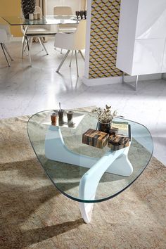 a glass coffee table sitting on top of a rug