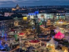 an aerial view of a city at night with christmas lights on the trees and carousels