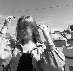 black and white photograph of a woman holding her hair in front of the city skyline