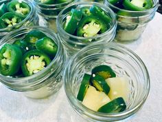 several glass jars filled with pickles on top of a table