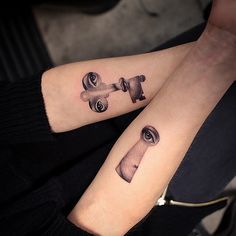 two people with matching tattoos on their arms