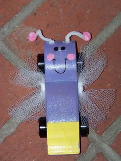 a purple and yellow skateboard with a face on it's back wheels are sitting on the ground