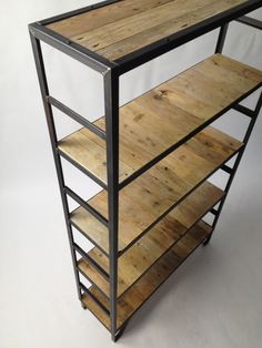 a wooden shelf sitting on top of a white floor next to a black metal frame