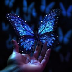 a hand holding a blue butterfly in front of a dark background with butterflies flying around