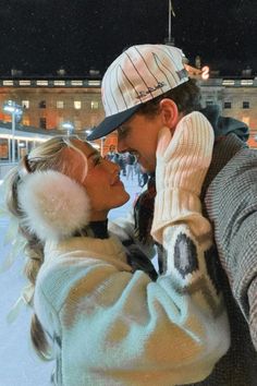 a man and woman standing next to each other in the snow