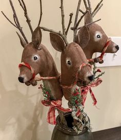 three deer heads are placed in a vase