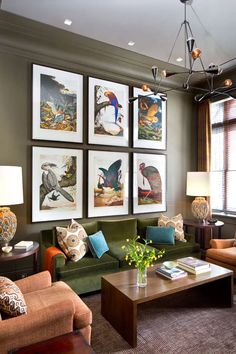 a living room filled with furniture and pictures on the wall above it's coffee table