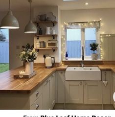 a kitchen filled with lots of counter top space next to a sink and window covered in lights