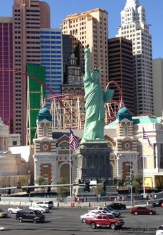 the statue of liberty is surrounded by tall buildings