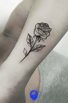 a black and white rose tattoo on the arm