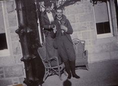 an old black and white photo of a man sitting in a chair