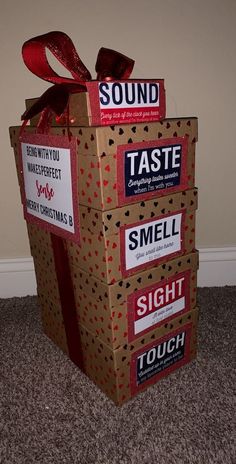 a cardboard box that has some stickers on it and is wrapped in red ribbon