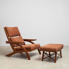 a wooden chair and ottoman sitting in front of a white wall with a light colored floor