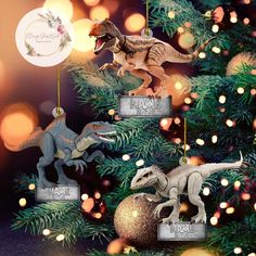 three dinosaur ornaments hanging from a christmas tree