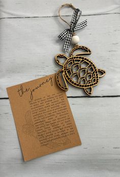 a wooden turtle ornament hanging from a string on top of a piece of paper