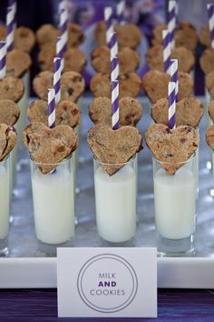 cookies and milk are arranged in small cups with straws sticking out of the top