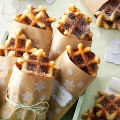 some food wrapped in brown paper sitting on top of a green table with white snowflakes