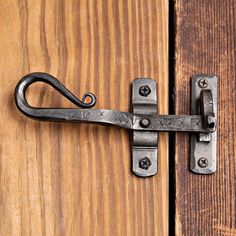 a close up of a metal latch on a wooden door with wood grained boards