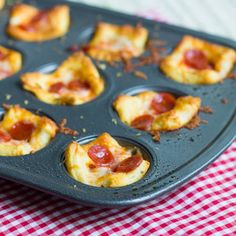 mini pizzas in a muffin tin on a red and white checkered tablecloth